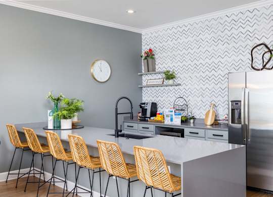 a kitchen with a large island and yellow chairs at Clear Creek Meadows Apartments, Copperas Cove