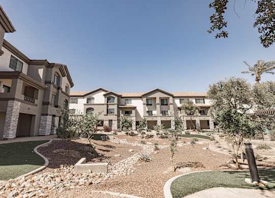A modern residential complex with a well-maintained garden in front.