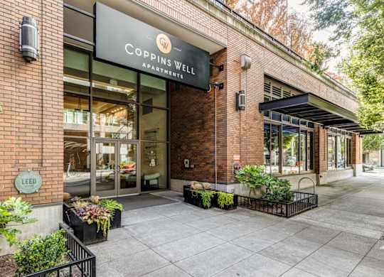 the facade of a building with a sign that reads Coppins Well Apartments