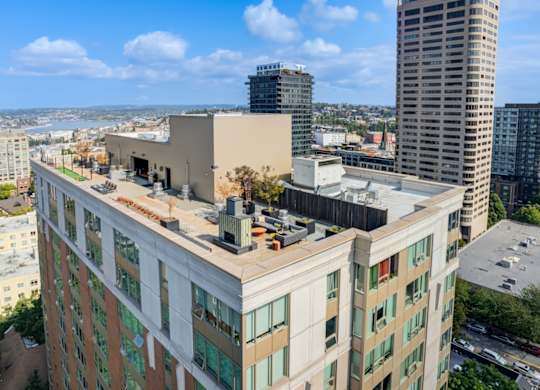 an aerial view of a tall building with a city in the background