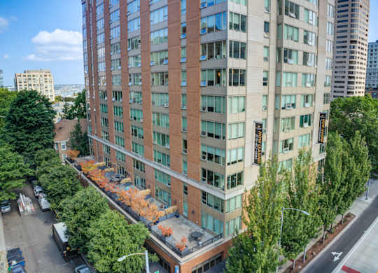 an aerial view of a tall building with trees in front of it