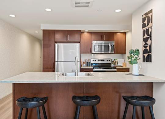 a kitchen with a large island with three stools in front of it