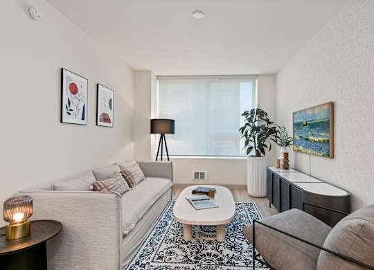 two couches and a coffee table in a living room with a large window