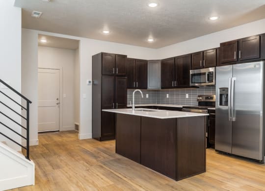 a kitchen with stainless steel appliances and dark wood cabinets