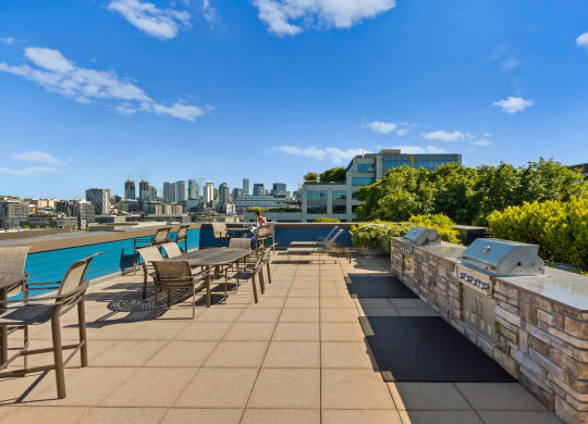 an outdoor terrace with tables and chairs and a pool with a cityscape in the background  at Dexter Lake Union, Seattle