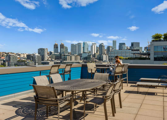 a woman sits at a table on a terrace with a view of the city in the  at Dexter Lake Union, Seattle, 98109