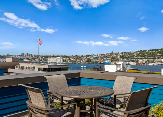 a patio with a table and four chairs overlooks a body of water  at Dexter Lake Union, Seattle, WA, 98109