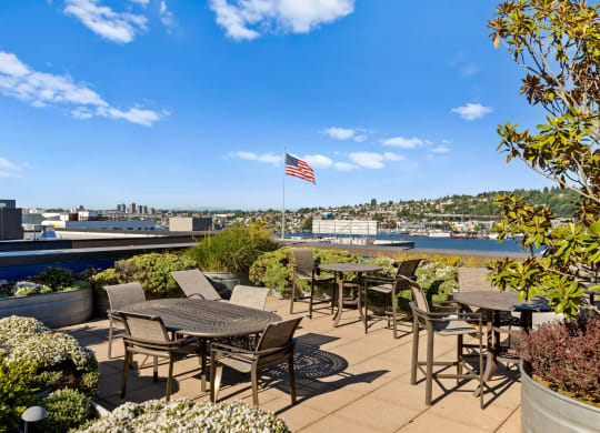 an outdoor patio with tables and chairs and an american flag  at Dexter Lake Union, Seattle, WA