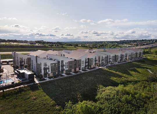 A large building complex with a swimming pool in the foreground.