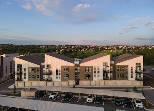 A modern building with a parking lot in front.