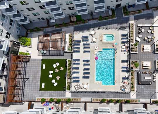 A pool and patio area in a courtyard surrounded by buildings.