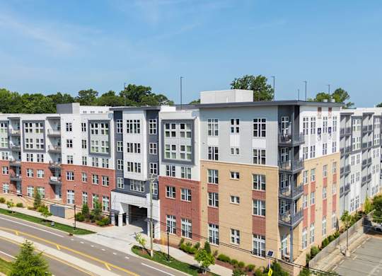 A row of modern apartment buildings with trees in the background.