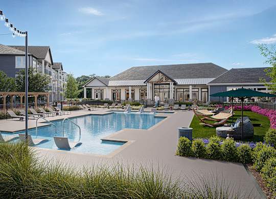 A large outdoor swimming pool surrounded by lounge chairs and umbrellas at Easton at Mountain Island apartments in Charlotte, NC.