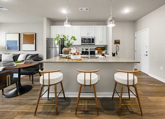 A kitchen with a bar stool in front of it.