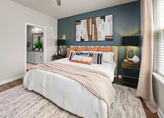 A bedroom with a large bed and a painting on the wall.
