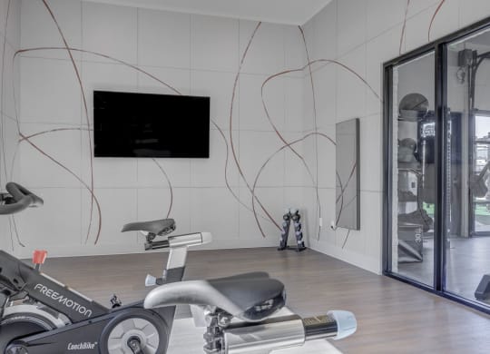 a gym with exercise equipment and a flat screen tv on the wall  at Embold, Lehi, 84043