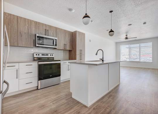 an empty kitchen with white cabinets and a counter top