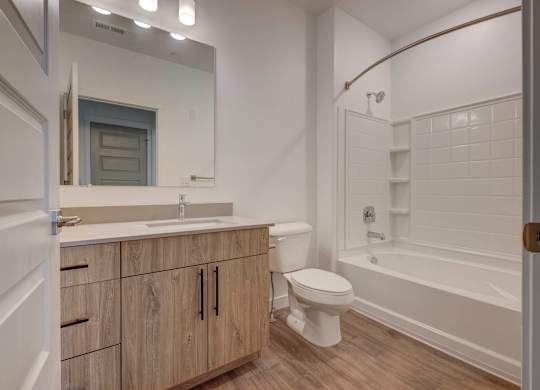 a bathroom with a toilet sink and shower and a mirror