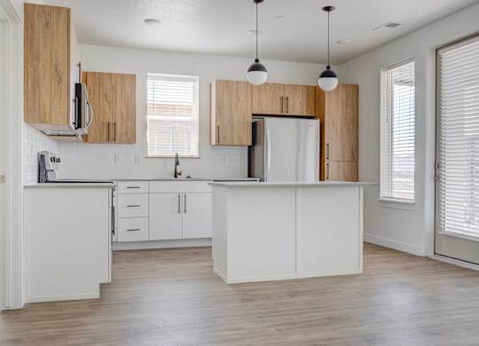 an empty kitchen with white cabinets and a white counter top