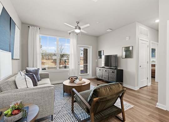 A living room with a grey couch, a wooden chair, and a coffee table.