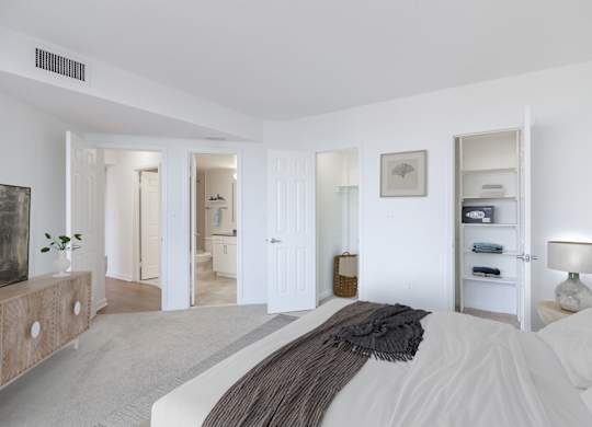 a bedroom with a bed and a dresser and a bathroom
