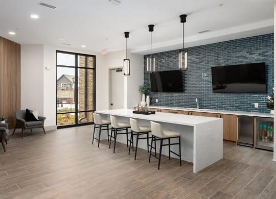 a kitchen with a large island with chairs and a television