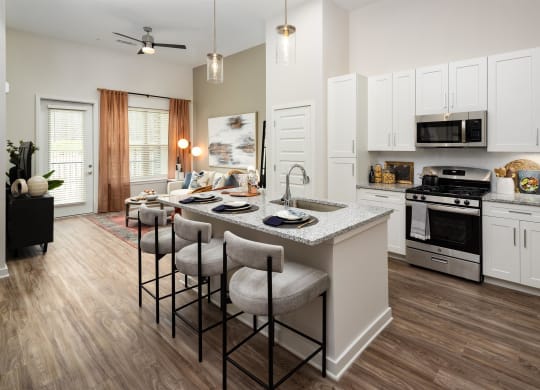 an open kitchen and living room with an island and stools