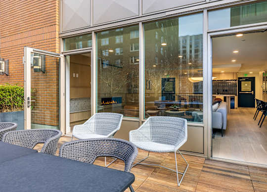 a patio with chairs and a table and sliding glass doors