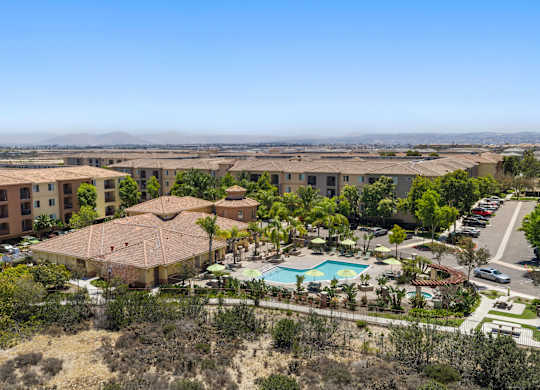 A large apartment complex with a pool and a view of the city.