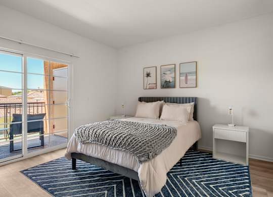 A bedroom with a large bed and a view of the outside.