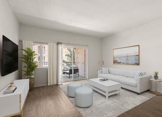 A living room with a white couch, a coffee table, and a television.