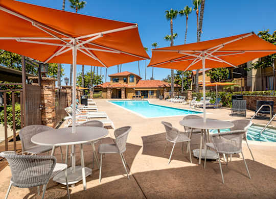 Swimming pool with tables and umbrellas next to it at Bella Terra, Vista, California, 92081