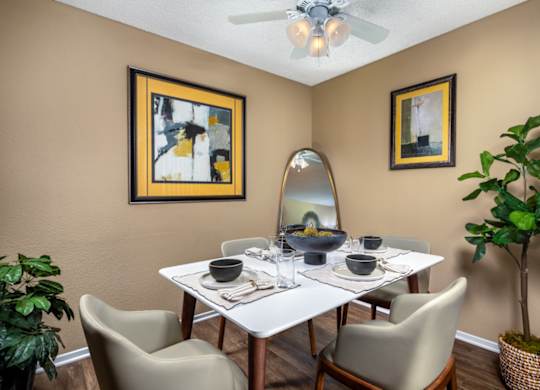 A dining room with a white table and chairs.