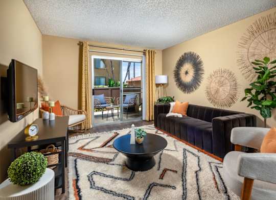 A living room with a black coffee table and a rug with a pattern.