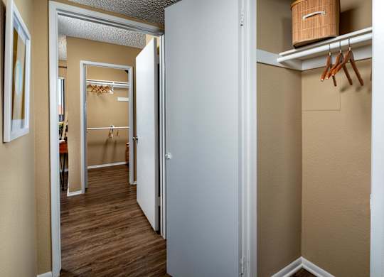 A white door is open to a hallway with a coat rack.
