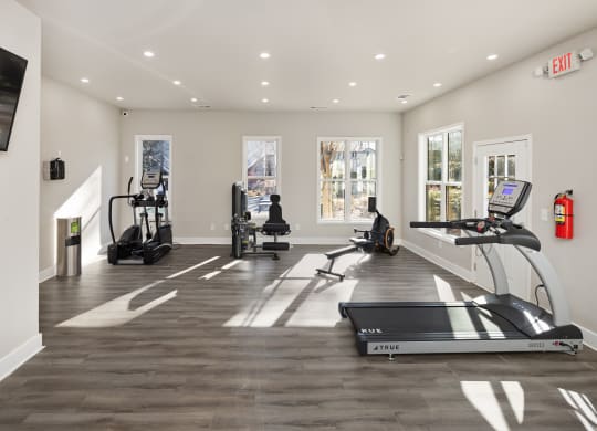 a gym with treadmills and other exercise equipment and a tv