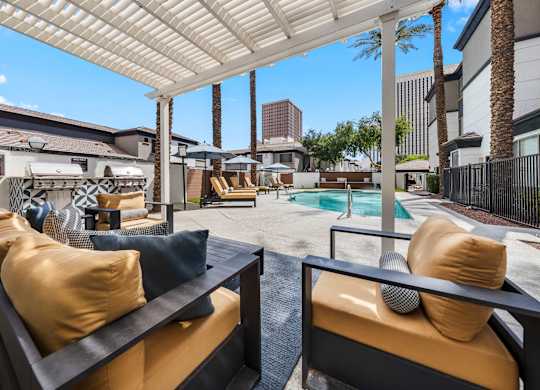 A patio with a pool and a white canopy.