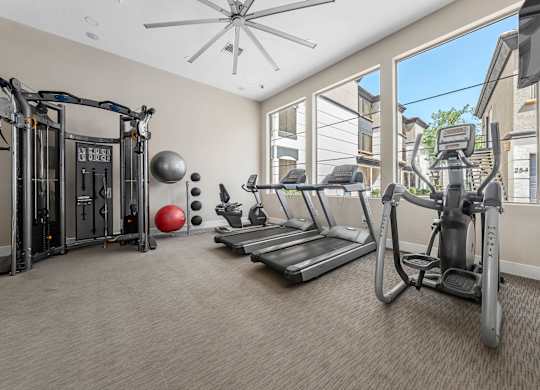 A well-equipped home gym with a treadmill, elliptical trainer, and other exercise machines.