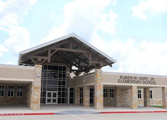 The front of Ruben W. Hope Jr. Elementary School is shown with a clear blue sky in the background.