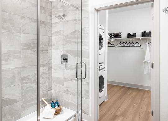 A bathroom with a walk-in shower and a laundry room.