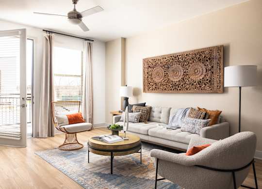 A living room with a grey couch, a coffee table, a chair, and a ceiling fan.