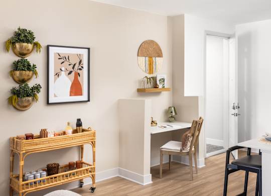 A room with a desk, chair, and shelf with various items.