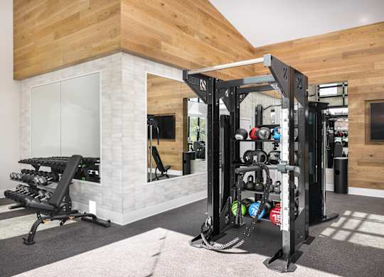 A gym with a weight rack and a bench.