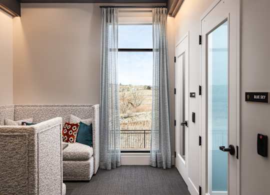 A well lit room with a sofa and a bed.