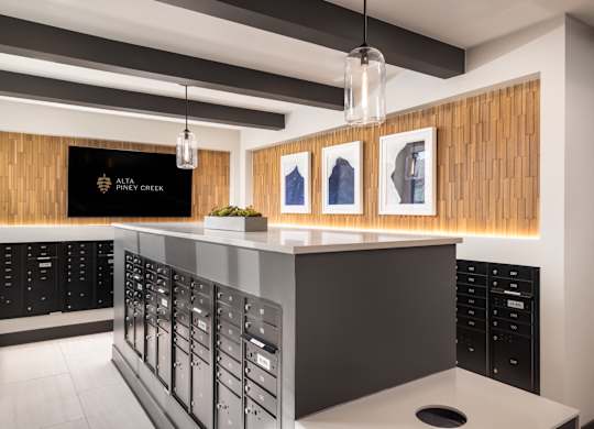 A modern bar with a wooden panel on the wall and a black and white counter.