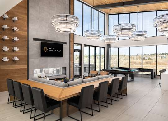 A conference room with a long table and chairs, a fireplace, and a large window with a view of the outdoors.