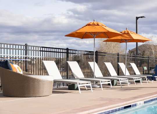 A poolside setting with sun loungers and umbrellas.