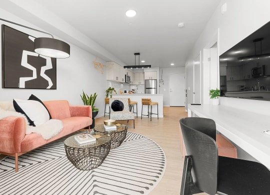 a living room with a pink couch and a black and white rug at Ion Town Center, Washington