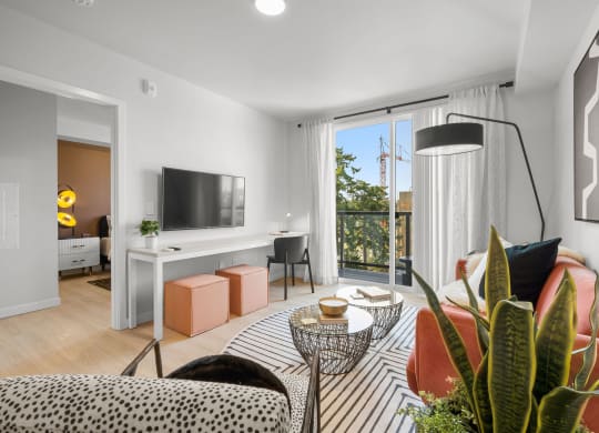 a living room with white walls and a sliding glass door that leads to a balcony at Ion Town Center, Shoreline