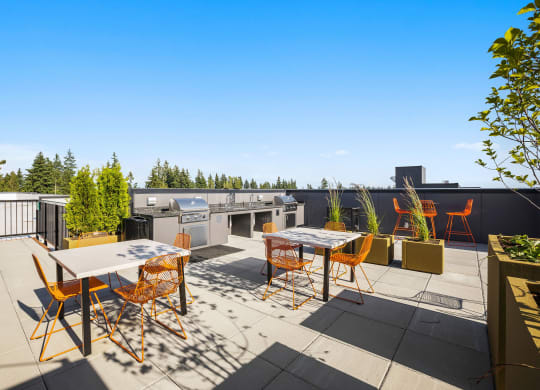 a patio with tables and chairs and a grill on a rooftop at Ion Town Center, Shoreline Washington